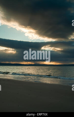 Sonnenlicht durch Regen Sturm über Nairn Strand in der Abenddämmerung Stockfoto