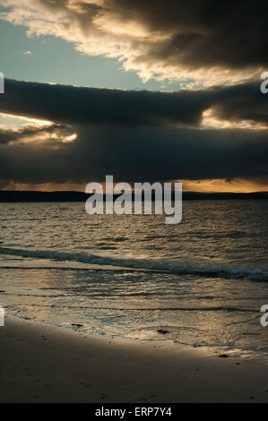 Sonnenlicht durch Regen Sturm über Nairn Strand in der Abenddämmerung Stockfoto