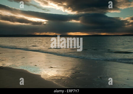 Sonnenlicht durch Regen Sturm über Nairn Strand in der Abenddämmerung Stockfoto