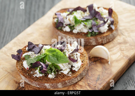 Roggen-Sandwich oder Bruschetta mit Ricotta, Kräutern und Basilikum Stockfoto