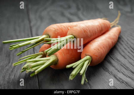 frische Karotten auf alten Eichentisch Stockfoto