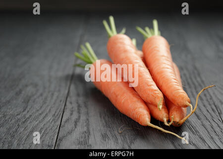frische Karotten auf alten Eichentisch mit Textfreiraum Stockfoto