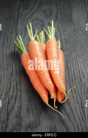 frische Karotten auf alten Eichentisch Stockfoto