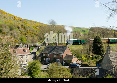 Dampfzug überqueren Eisenbahnbrücke in Corfe, Dorset, April, Wagen ziehen. Stockfoto