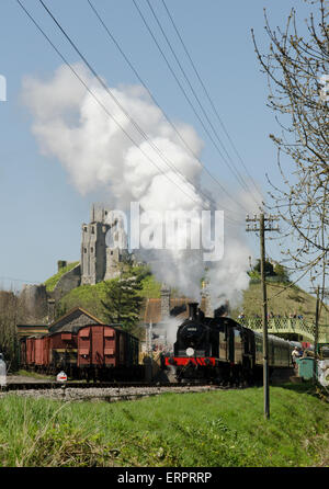 Verlassen Sie den Bahnhof am Corfe Dampfzug. Corfe Castle im Hintergrund. Dorset, UK. April. Stockfoto