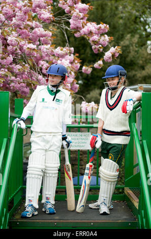 Zwei Mädchen warten auf ein Juniorinnen-Cricket Fledermaus entsprechen in Wiltshire UK Stockfoto