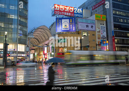 Straßenbahn entlang der Straße in der Abenddämmerung, Hiroshima, Präfektur Hiroshima, Japan Stockfoto