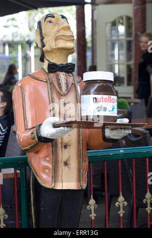 Holzstatue der Kellner mit einem Tablett mit einem Glas des Riesen Nutella Stockfoto