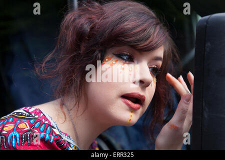 Calderdale, Yorkshire, 7. Juni 2015. Helen Rees 21, ihr Make-up Verstellen an den Hebden Bridge Festival. Die 8 Hebden Bridge handgefertigte Parade, die Kunst der Handarbeit. Ein Festival der Veranstaltungen mit Künstlern und Darstellern, die ein erstaunliches Ereignis erstellen, eine Gelegenheit, die für bis zu 1000 Personen Tanz in den Straßen von Hebden Bridge, die von Tausenden sah nach unten. Stockfoto