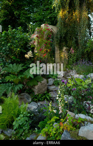 Ein Steinbogen, umgeben von naturalistischen Pflanzung in der vergessen Torheit Garten von The Hampton Court Flower Show, 2014 Stockfoto