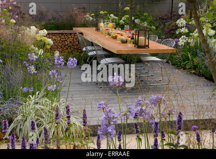 Lavandula und Agapanthus neben einem Essbereich im Vestra Reichtum Vista Garden auf der Hampton Court Flower Show Stockfoto