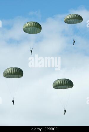 US Army Fallschirmjäger mit dem Fallschirm über der historischen La Fiere Drop-Zone zum Gedenken an die 71. Jahrestag des d-Day Invasion 7. Juni 2015 in der Nähe von Sainte Reine Eglise, Normandie, Frankreich. Stockfoto