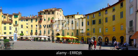 Schöne Runde Marktgebiet im Zentrum der ummauerten Stadt Lucca mit der farbenfrohen Gebäuden und Restaurants im freien Stockfoto