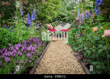 Chelsea Flower Show 2015, Bank im Garten umgeben von Blumen mit Kiesweg Stockfoto