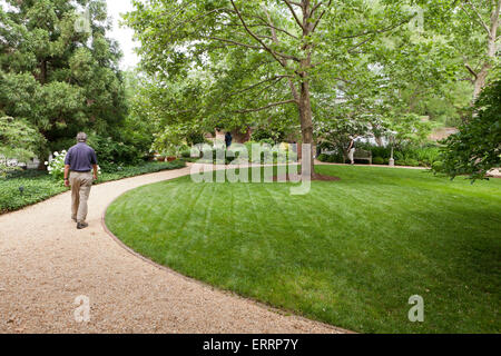 Man Walking auf Schotterweg in öffentlichen Garten - USA Stockfoto