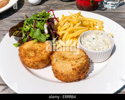 Ein Café Mittagessen mit hausgemachte Fischfrikadellen mit Salat garnieren, französische gebratene Kartoffeln und Tatar-Sauce mit Kapern Stockfoto