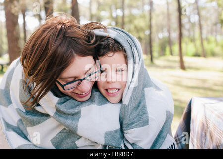 Glückliche Mutter und Sohn in Decke im Wald gehüllt Stockfoto