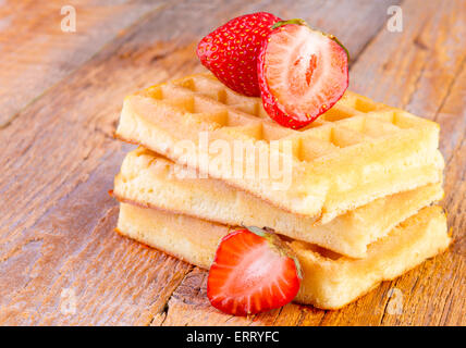 hausgemachte Waffeln mit Erdbeeren auf hölzernen Hintergrund Stockfoto