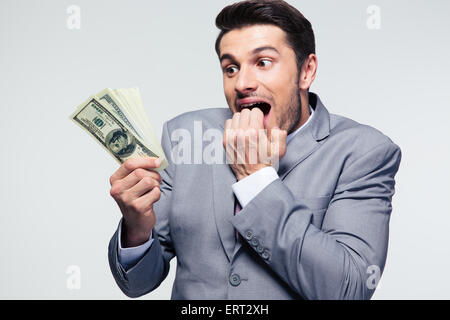 Gut aussehend Geschäftsmann mit US-Dollar auf grauem Hintergrund Stockfoto