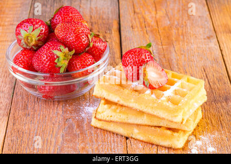 hausgemachte Waffeln mit Erdbeeren auf hölzernen Hintergrund Stockfoto