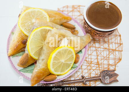 Türkische Baklava und Kaffee auf einem Teller mit in Scheiben geschnittenen Zitronen Stockfoto