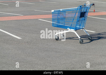 Leer Warenkorb steht auf einem Parkplatz in der Nähe von Supermarkt Stockfoto