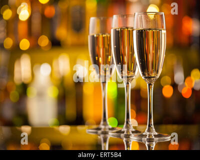 Feier-Thema mit drei Gläser Champagner. Flaschen auf Hintergrund Unschärfe Stockfoto