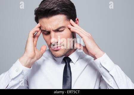 Porträt eines Geschäftsmannes denken über grauen Hintergrund Stockfoto