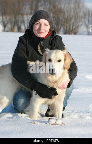 Frau und Golden Retriever im Schnee Stockfoto