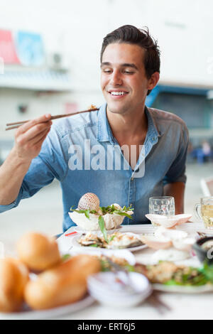 Touristischen Mann isst asiatisches Essen lokalen Straßencafé, Lächeln Stockfoto