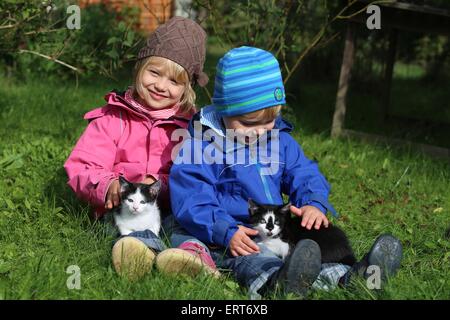 Kinder und Hauskatzen Stockfoto