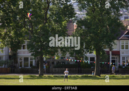 Man fliegt Kite an einem Sommerabend vor der Edwardian Periode Häuser in Ruskin Park, Süd-London. Stockfoto