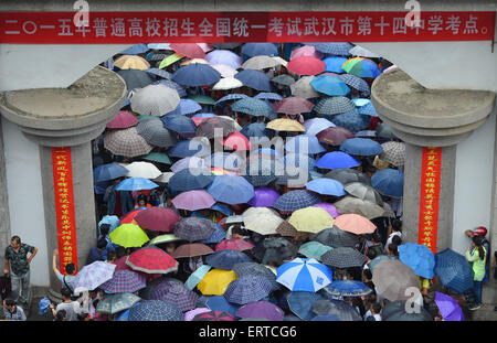 Wuhan, Hubei, China. 7. Juni 2015. Kandidaten eine Prüfung zu beenden und Fuß aus Nr. 14 Middle School in Wuhan als ihre Eltern halten Sie Sonnenschirmen draußen warten. Insgesamt 9,42 Millionen chinesische Schülerinnen und Schüler fing '' Gaokao'', die jährlichen nationalen College-Aufnahmeprüfung gestern. Der Test nennt man oft einen '' Kampf um Schicksal zu bestimmen '' wie seine Ergebnisse entscheiden, ob ein Student aufs College, zurück in die Schule um ein weiteres Jahr geht oder versucht, einen Job zu finden. © SIPA Asien/ZUMA Draht/Alamy Live-Nachrichten Stockfoto