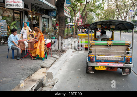 Wahrsagerin auf den Straßen von Bangkok mit einem Tuk-Tuk-Taxi wartet am Straßenrand Bangkok Thailand Stockfoto