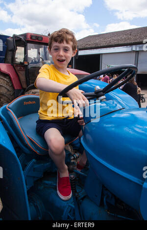 Sechs Jahre alter Junge auf einem Oldtimer-Traktor Fordson Super Major Cheriton mittleren Farm auf offenen Hof Sonntag, Hampshire, England, UK Stockfoto