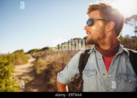 Im Freien Schuss des Jünglings Wandern in der Natur entfernt betrachten. Kaukasischen Mann eine Wanderung an einem sonnigen Tag zu genießen. Exemplar. Stockfoto