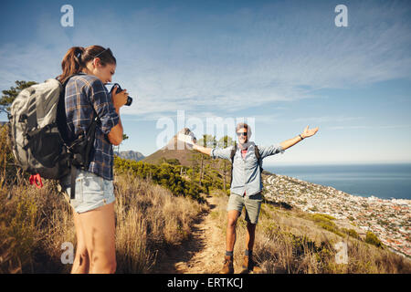 Im Freien Schuss der jungen Frau, die ihrem Freund in Landschaft beim Wandern zu fotografieren. Wanderer-Paar genießt während Sommer vacatio Stockfoto
