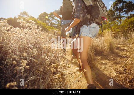 Bild von Mann und Frau zu Fuß auf Feldweg Trail beschnitten. Junges Paar Wandern am Berg an sonnigen Tag. Stockfoto