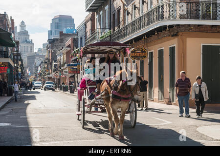 Touristen Sightseeing in einer Kutsche in die Bourbon Street im French Quarter von New Orleans, Louisiana, USA im Sommer Stockfoto