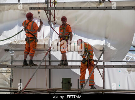 Bauarbeiter errichten Gerüste und Begrenzenden es in Kunststoff Zelt zum Schutz vor Wetter, Großbritannien Stockfoto
