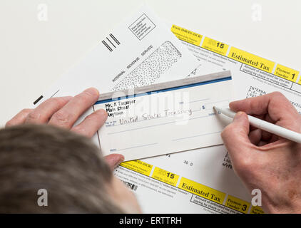 Mann schreiben Schecks zu Internal Revenue Service IRS Form 1040-ES für die Zahlung der geschätzten Steuern im Jahr 2015 Stockfoto