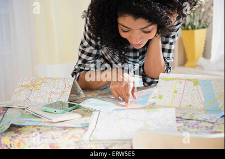 Gemischte Rassen Frau Planung Roadtrip mit Karten Stockfoto