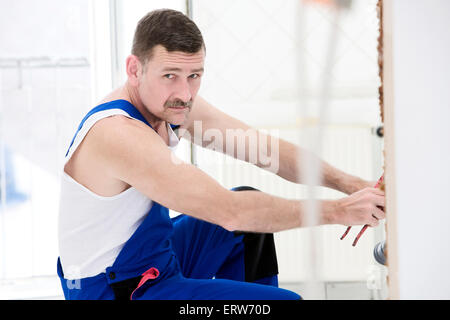 ein Mechaniker arbeiten an Sanitär in einer Wohnung Stockfoto
