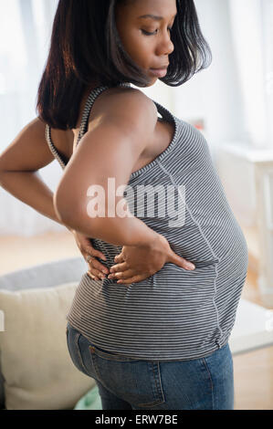 Schwarze schwangere Frau den Rücken dehnen Stockfoto