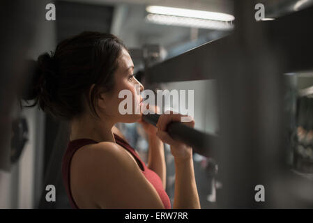 Gemischte Rassen Frau mit Heimtrainer im Fitness-Studio Stockfoto