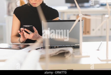 Gemischte Rassen Architekt mit Windmühle Modelle mit Handy Stockfoto