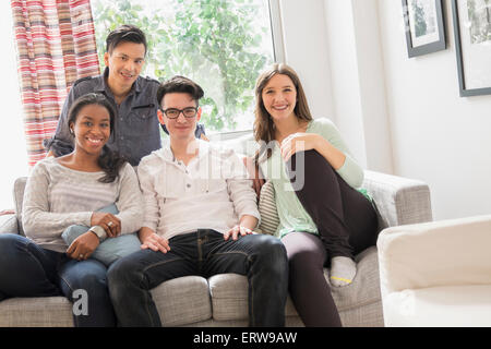 Lächelnden Freunde auf sofa Stockfoto