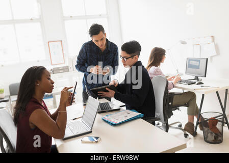 Geschäftsleute, die mit Technik im Büro Stockfoto