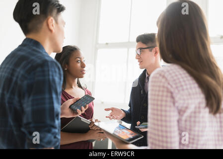 Geschäftsleute, die gemeinsam im Büro mit Technik Stockfoto