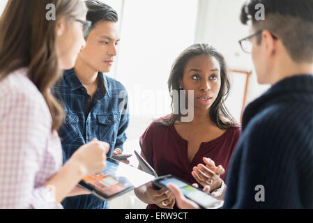 Geschäftsleute, die gemeinsam im Büro mit Technik Stockfoto